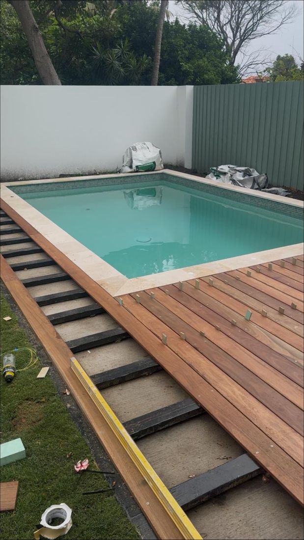Deck boards going down over the frame along the pool edge