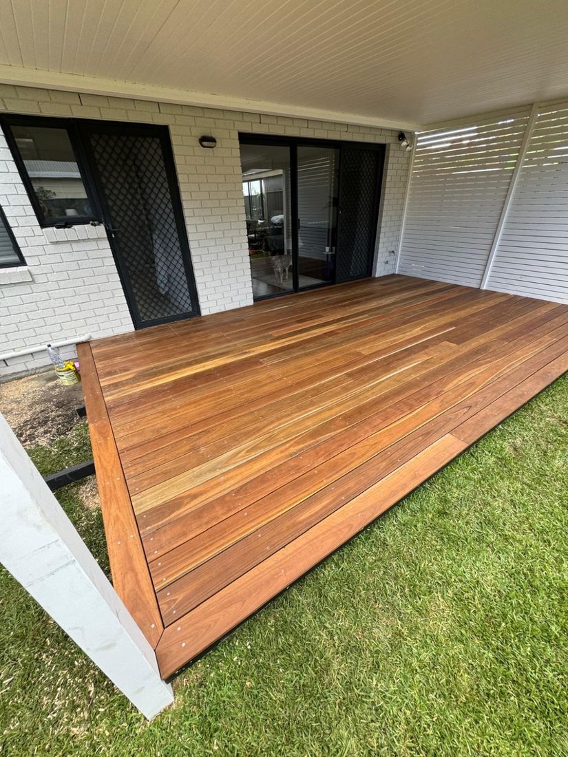 The finished timber deck under a covered patio, beside a lawn