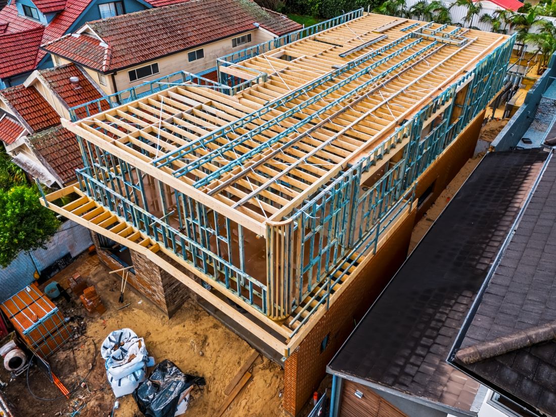 Aerial view of a two-storey timber and steel frame standing on a brick base