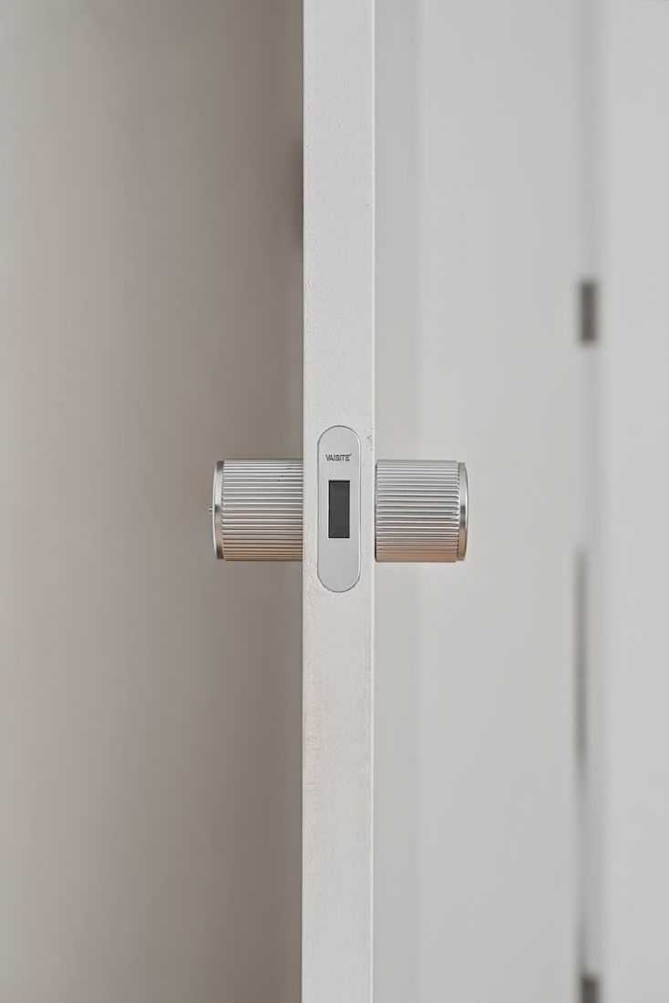 Fluted cylindrical handles on the edge of a microcement-finished door
